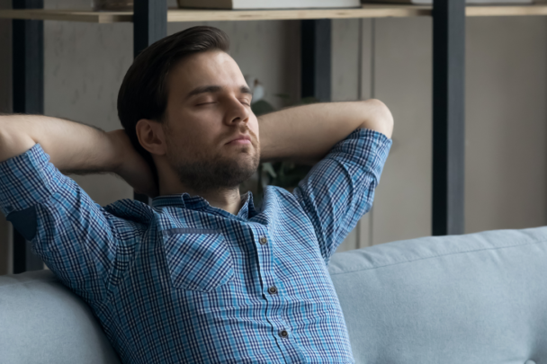 Man zit op de bank met zijn ogen dicht