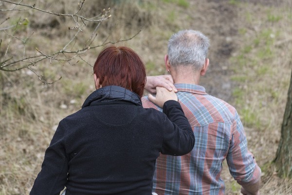 vrouw legt hand op schouder van man