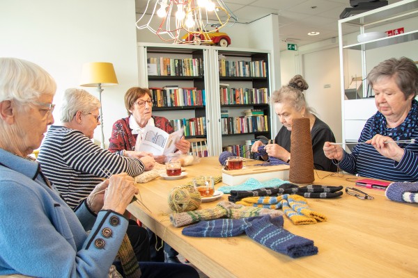 vrouwen zitten samen te breien