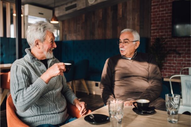 Twee oudere mannen drinken samen koffie