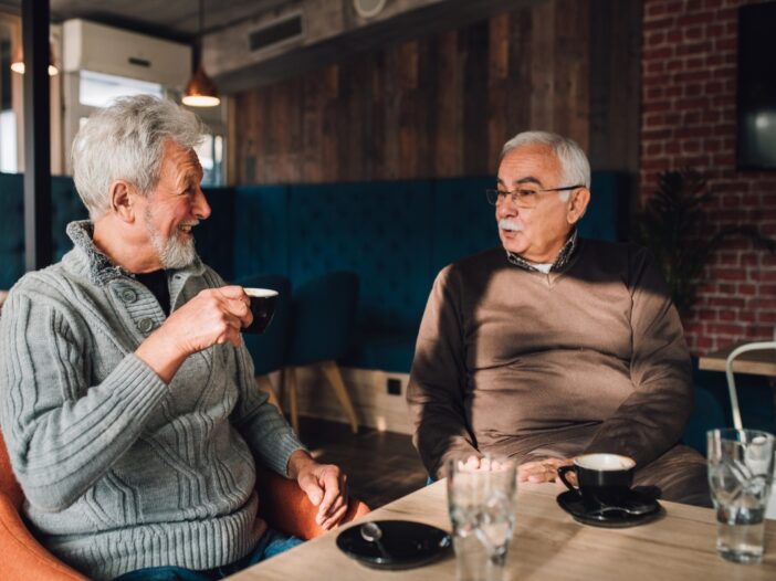 Twee oudere mannen drinken samen koffie