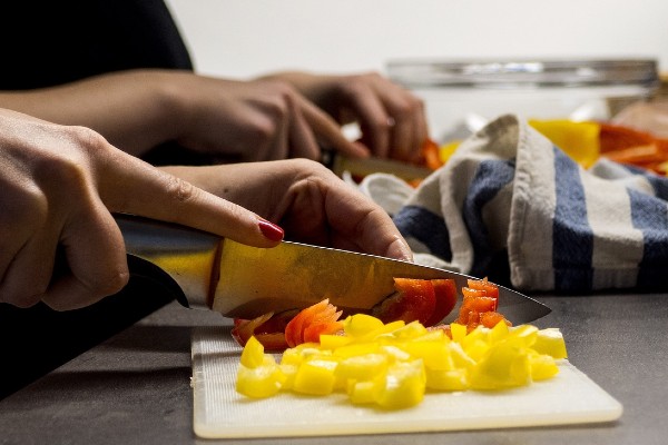 twee mensen snijden paprika