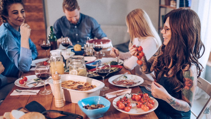 mensen zitten samen aan tafel te eten