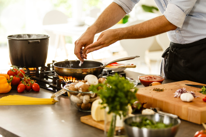 man die een maaltijd aan het koken is