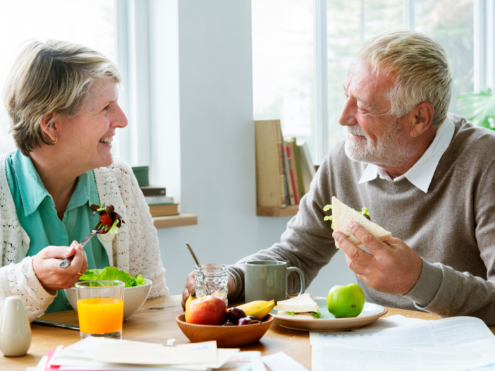 twee ouderen eten samen aan tafel