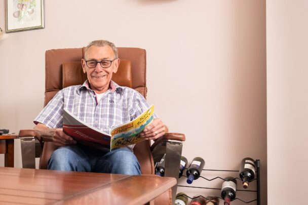 man in stoel aan tafel met een tijdschrift