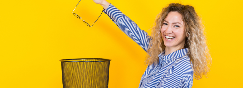 vrouw gooit oude bril in de prullenbak