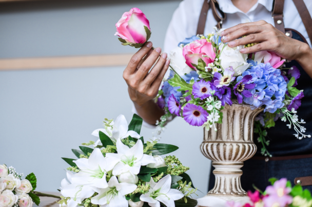 vrouw schikt bloemen in een vaas