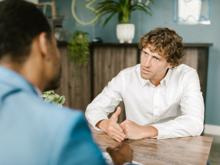 twee mannen voeren een gesprek aan tafel