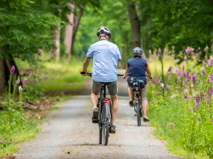 twee mensen samen op de fiets in het bos