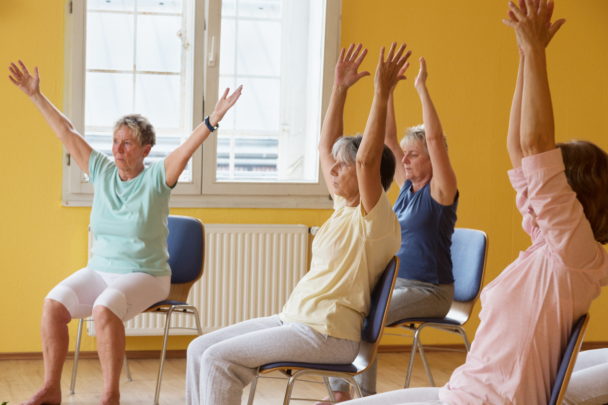 groepje ouderen doet aan stoelgym