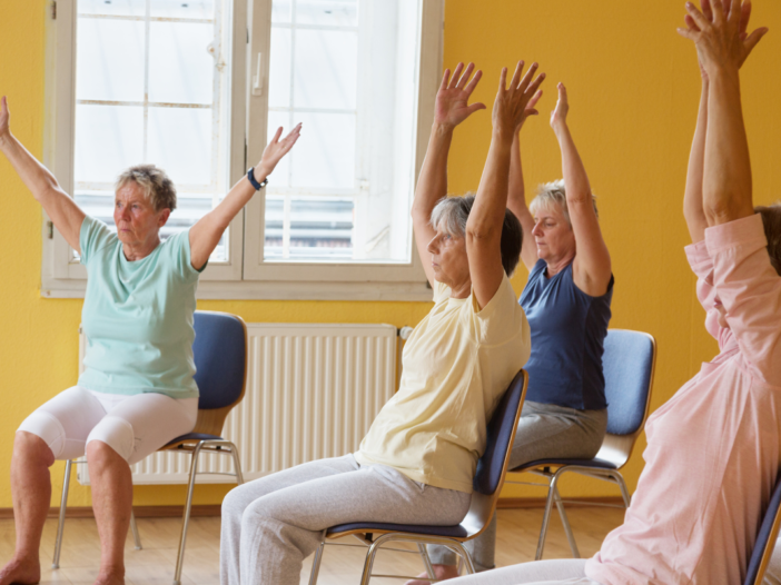 groepje ouderen doet aan stoelgym