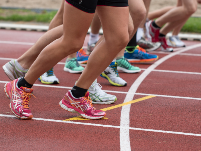 mensen lopen wedstrijd op een atletiekbaan