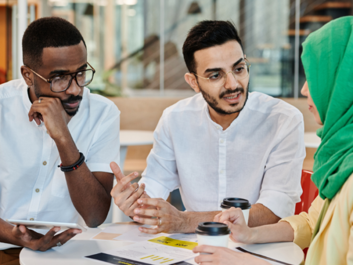 drie mensen van verschillende culturele achtergronden zijn met elkaar in gesprek