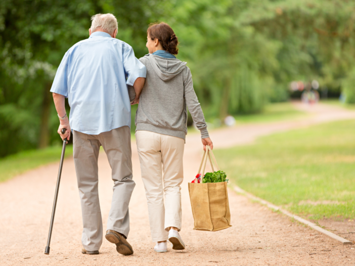 vrouw en oudere man wandelen samen