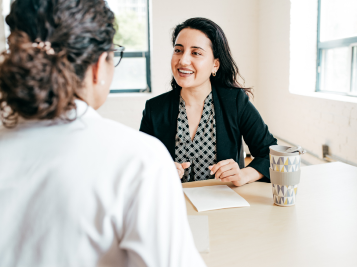 twee vrouwen voeren een gesprek aan tafel