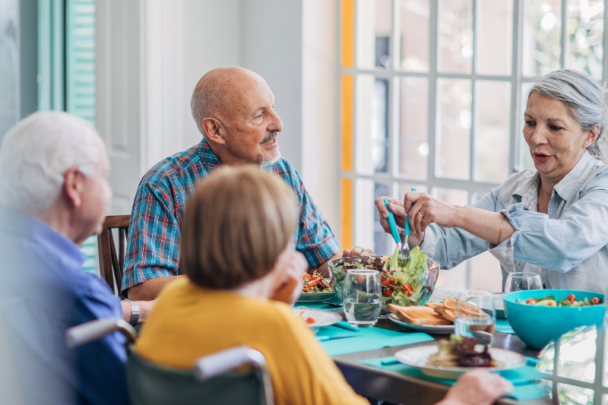 vier senioren eten samen een maaltijd