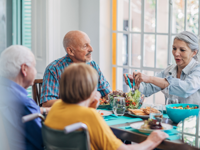 vier senioren eten samen een maaltijd