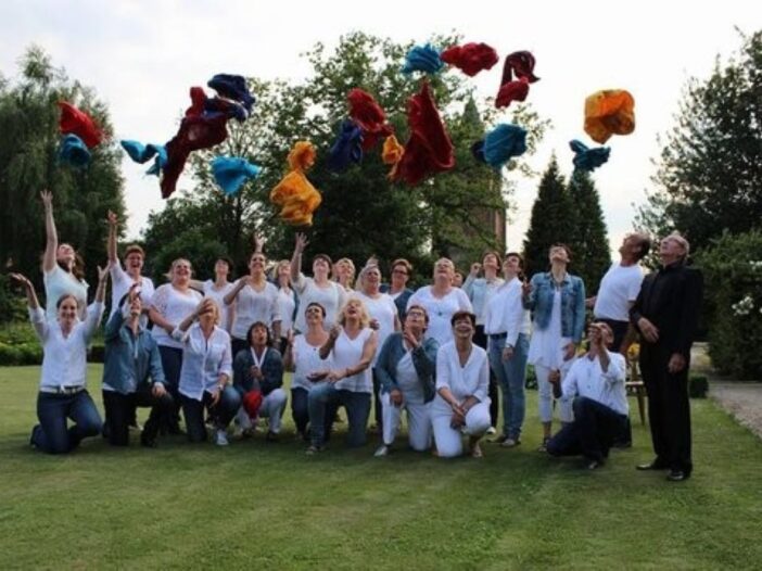 Dit is de zanggroep multivoices in duizel. Ze hebben allemaal witte kleren aan en gooien spullen de lucht in.