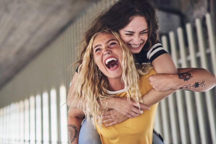 Twee vriendinnen hebben samen plezier, de een houdt de ander stevig vast