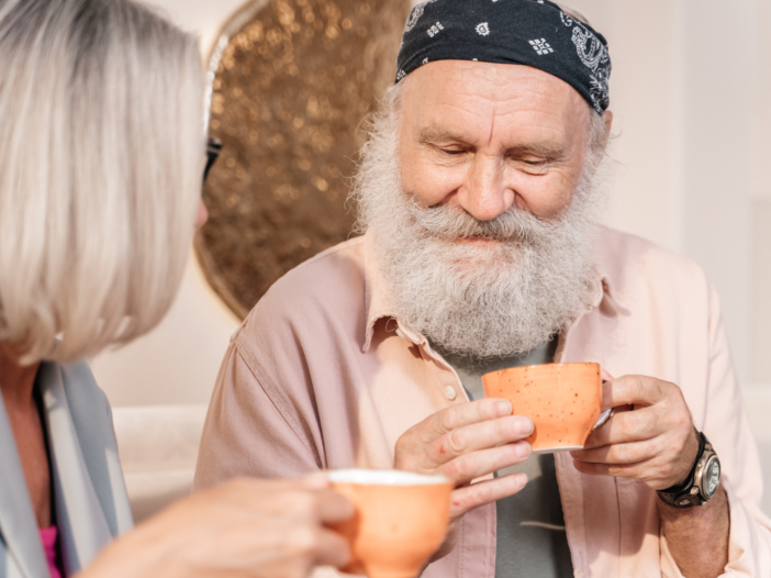 Man en vrouw van oudere leeftijd drinken samen koffie.