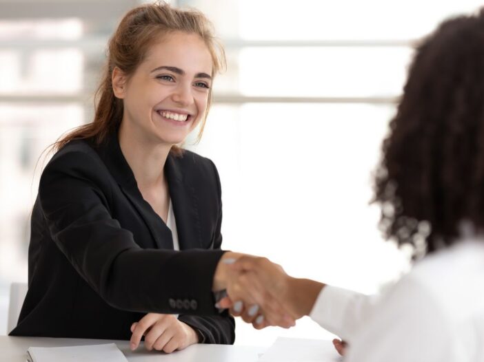 Twee vrouwen geven elkaar een hand