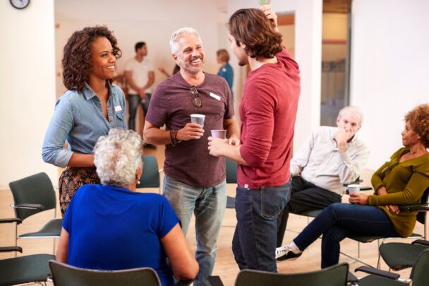 Vijf mensen van allerlei leeftijden en afkomst zijn in gesprek met elkaar.