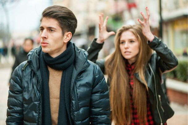 Jonge man en vrouw hebben een discussie op straat. De vrouw houdt geërgerd haar handen in de lucht.