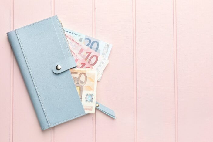 Lichtblauwe portemonnee met daaruit stekend een aantal euro biljetten.