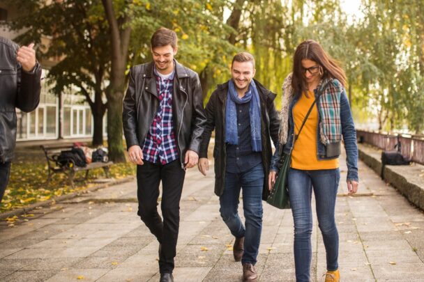 Twee mannen en een vrouw maken een wandeling buiten.