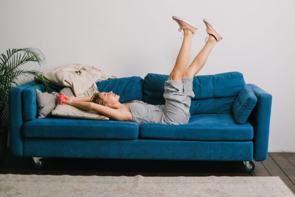 Vrouw ligt te relaxen op een bank.