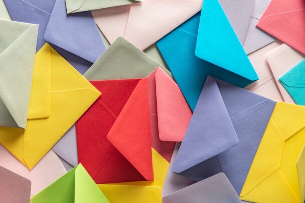 Allerlei gekleurde enveloppen op en over elkaar gelegd.