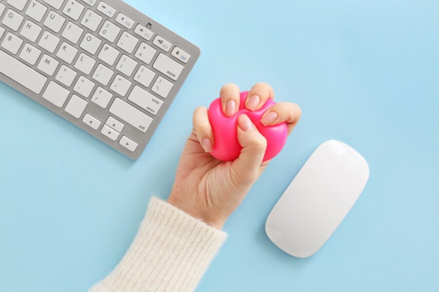 Vrouwenhand knijpt in rode stressbal