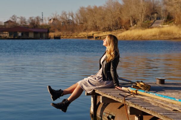 Dame op steiger geniet van omgeving