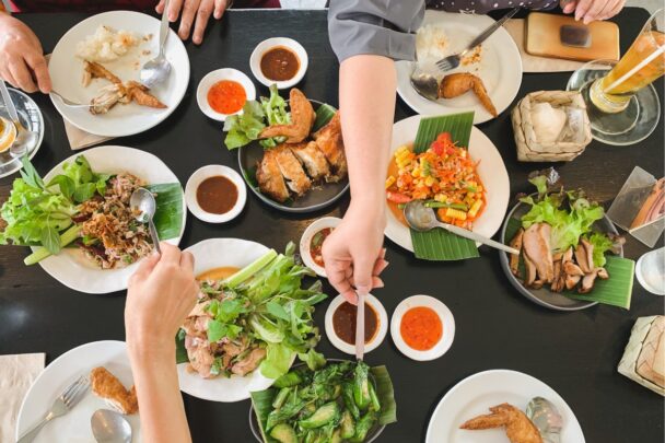 Tafel met borden waar mensen eten vanaf halen.
