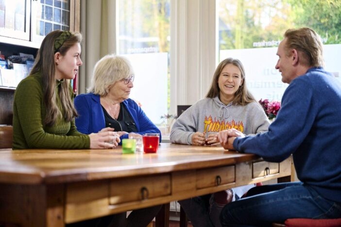 Jong en oud praten samen aan tafel