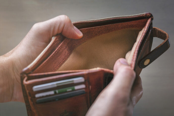 Iemand houdt een lege portemonnee open.