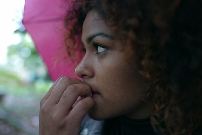 Vrouw kijkt bezorgd en bijt aan haar nagels.