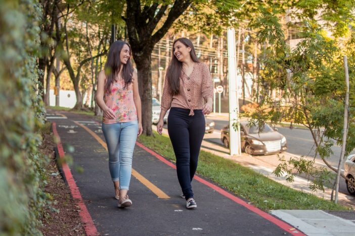 Twee jonge vrouwen wandelen samen over fietspad