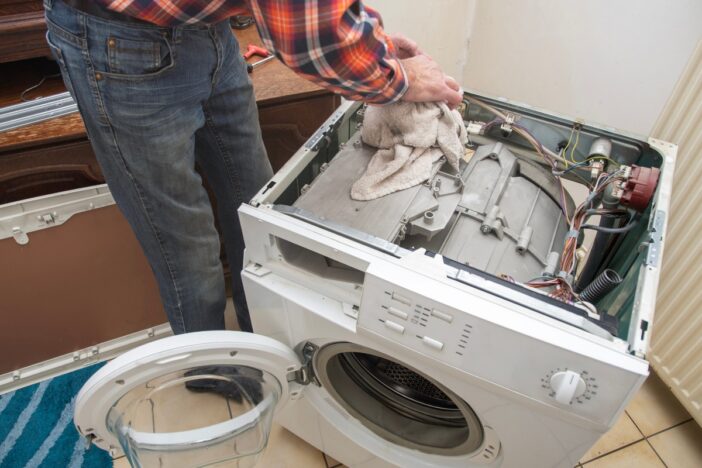 Monteur repareert een wasmachine