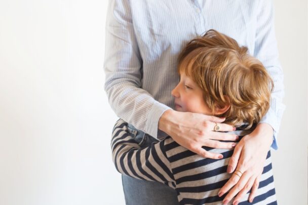 Kind knuffelt een volwassene.