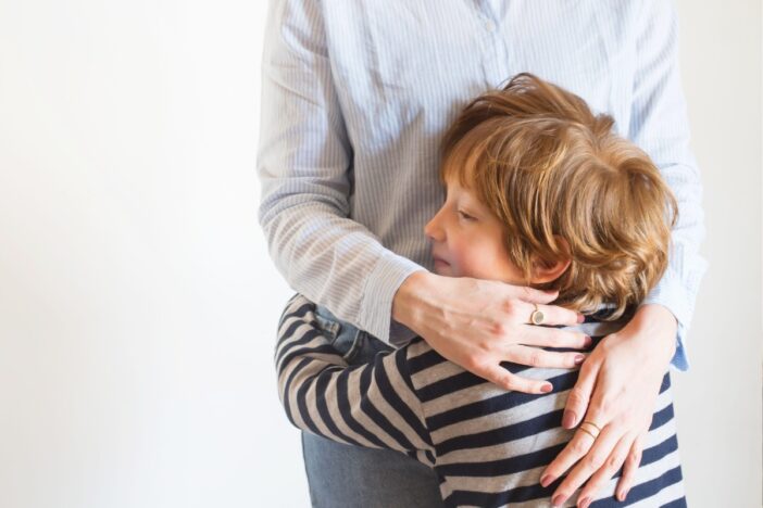 Kind knuffelt een volwassene.