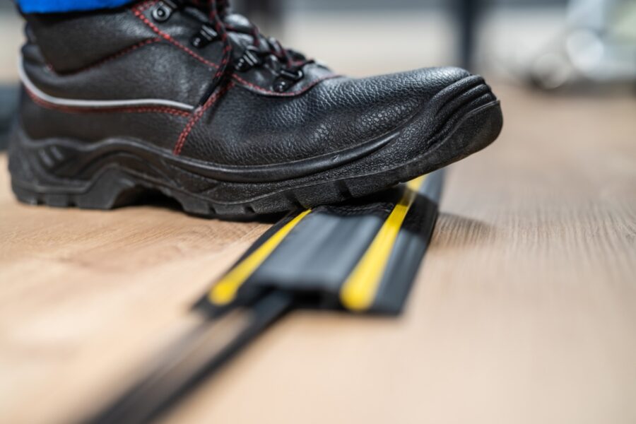 Stevige zwarte schoen op een kabelgootje.