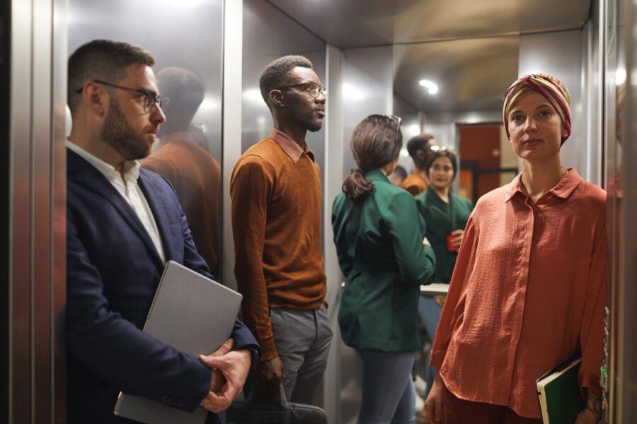 Vier mensen staan met elkaar in een lift.