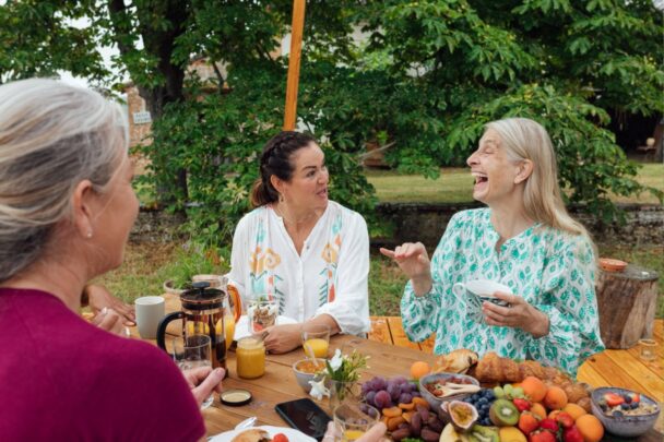 Drie vrouwen ontbijten samen in de tuin