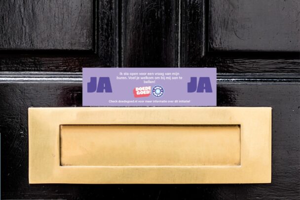 Ja-JA sticker boven de brievenbus van een zwarte voordeur