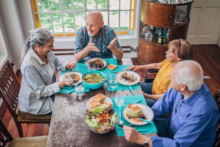 Ouderen zitten samen aan tafel te eten.